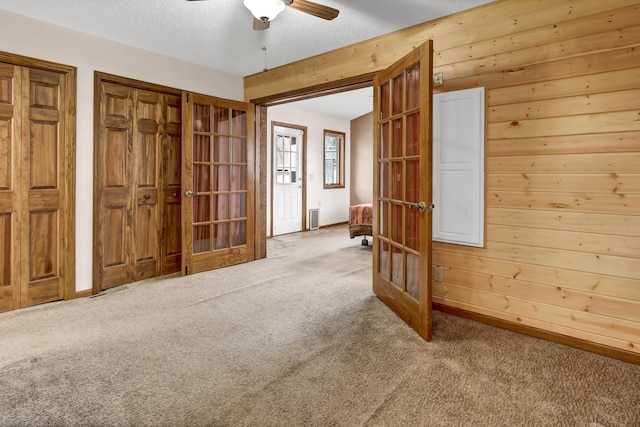 spare room with ceiling fan, french doors, and carpet