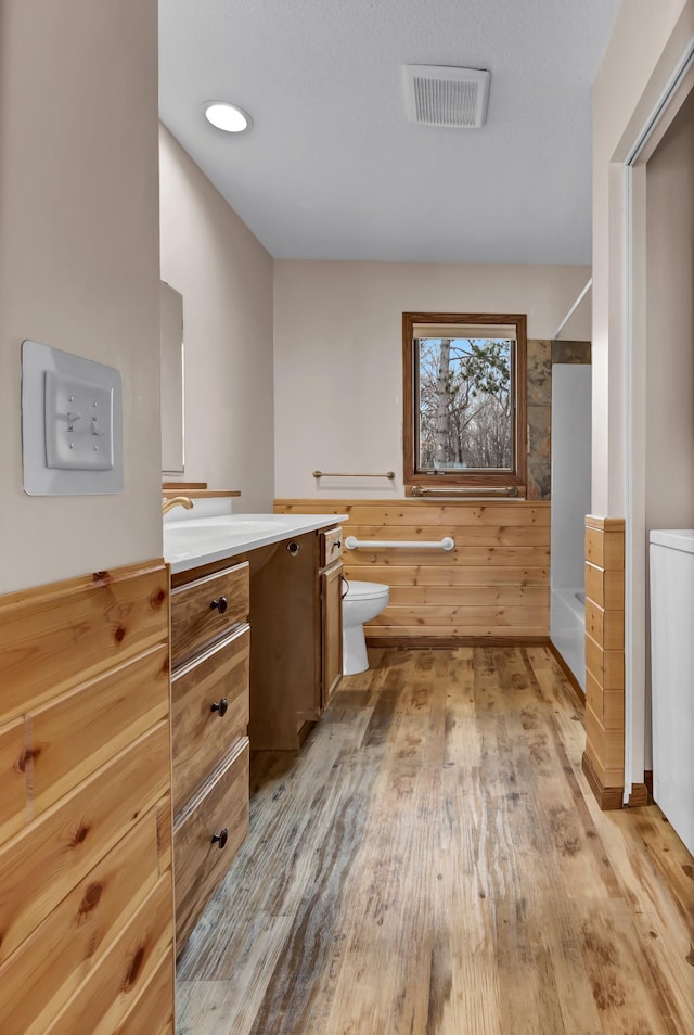 full bathroom featuring bathtub / shower combination, vanity, visible vents, toilet, and wood finished floors