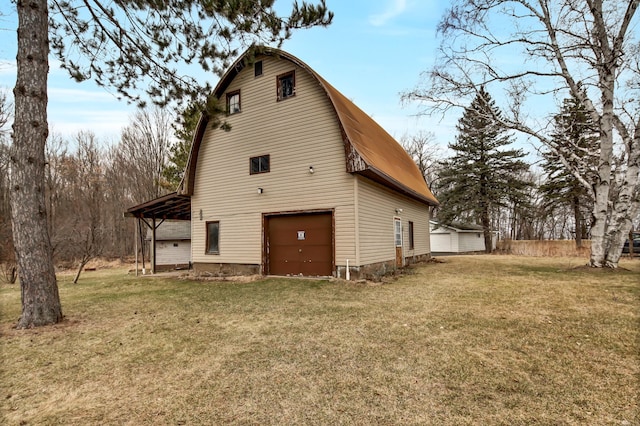 view of side of property featuring a carport, a gambrel roof, and a yard
