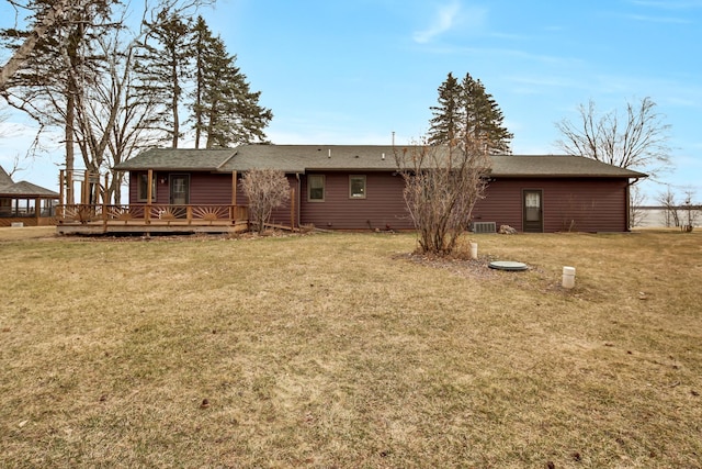 rear view of house with a shingled roof, a yard, cooling unit, and a deck