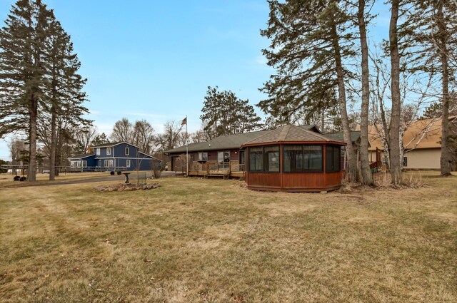 view of yard featuring a wooden deck and a sunroom