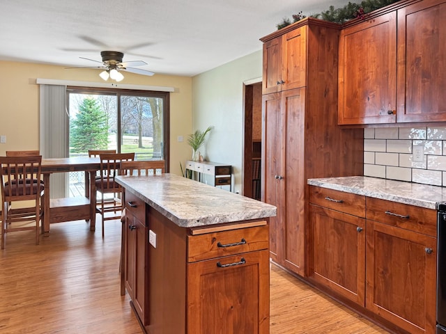 1126 US Highway 59, Garvin, MN 56132 - kitchen featuring a ceiling fan, light wood-style floors, a center island, tasteful backsplash, and brown cabinetry