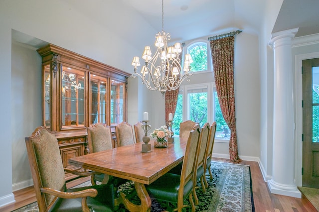 13980 Emerald Rdg, Minnetonka, MN 55305 - dining area with ornate columns, a chandelier, wood finished floors, and high vaulted ceiling