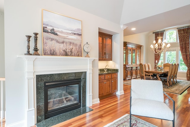 13980 Emerald Rdg, Minnetonka, MN 55305 - living area with light wood-type flooring, a chandelier, a glass covered fireplace, and recessed lighting