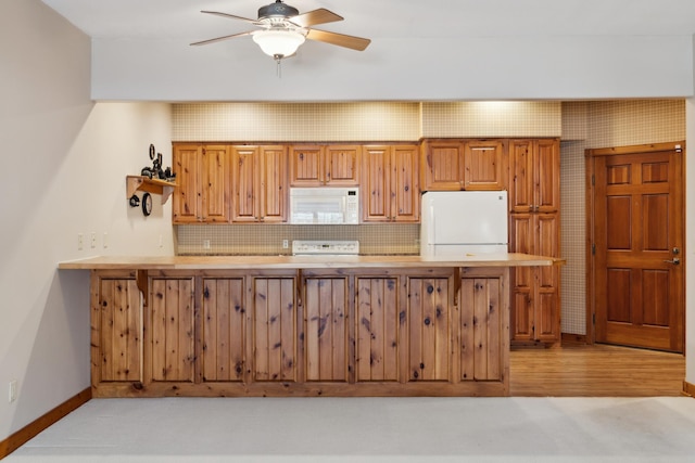 36306 Pine Bay Cir Unit 104, Crosslake, MN 56442 - kitchen featuring white appliances, light countertops, baseboards, ceiling fan, and brown cabinets