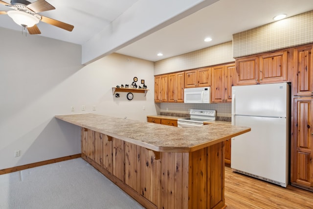 36306 Pine Bay Cir Unit 104, Crosslake, MN 56442 - kitchen featuring white appliances, a peninsula, light countertops, baseboards, and tasteful backsplash