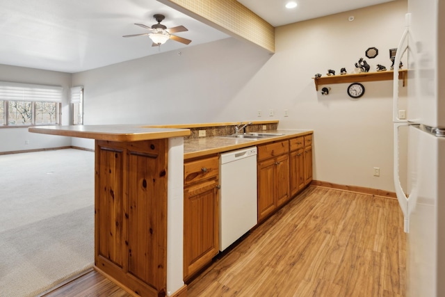 36306 Pine Bay Cir Unit 104, Crosslake, MN 56442 - kitchen featuring white appliances, a sink, a peninsula, baseboards, and brown cabinets