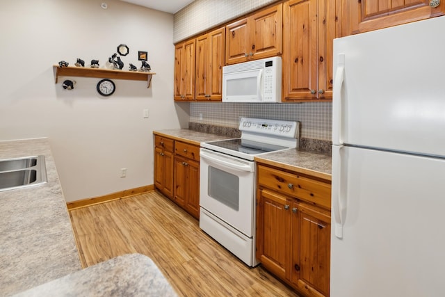 36306 Pine Bay Cir Unit 104, Crosslake, MN 56442 - kitchen with white appliances, backsplash, light wood finished floors, brown cabinets, and baseboards