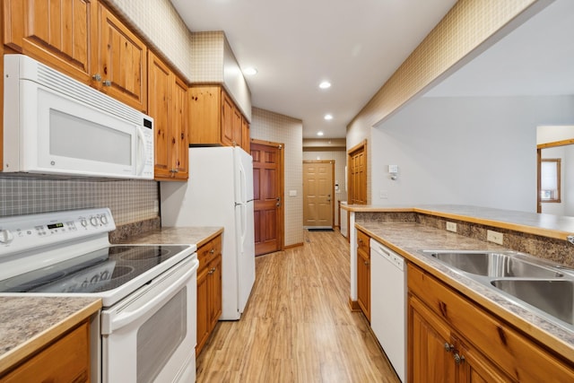 36306 Pine Bay Cir Unit 104, Crosslake, MN 56442 - kitchen with white appliances, light wood-style flooring, brown cabinets, a sink, and recessed lighting