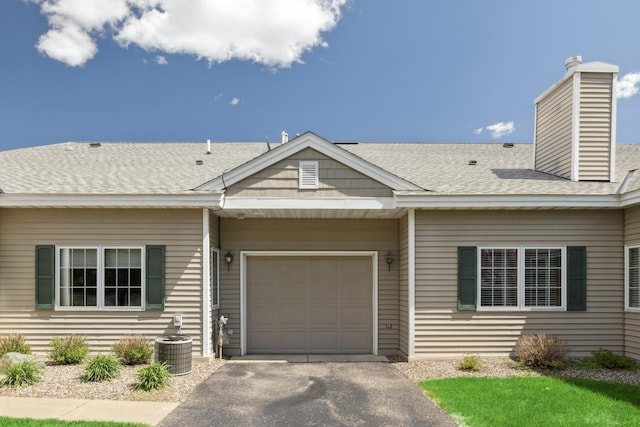 36306 Pine Bay Cir Unit 104, Crosslake, MN 56442 - view of front of property featuring an attached garage, driveway, central AC, and a shingled roof