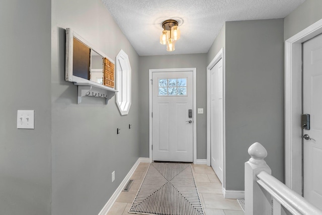 doorway with a textured ceiling, visible vents, and baseboards