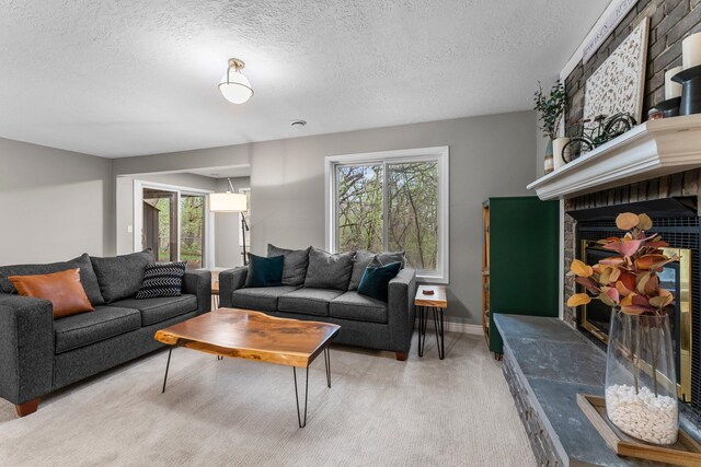 living area featuring plenty of natural light, a textured ceiling, and a fireplace
