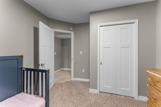 bedroom with carpet floors, baseboards, and a closet