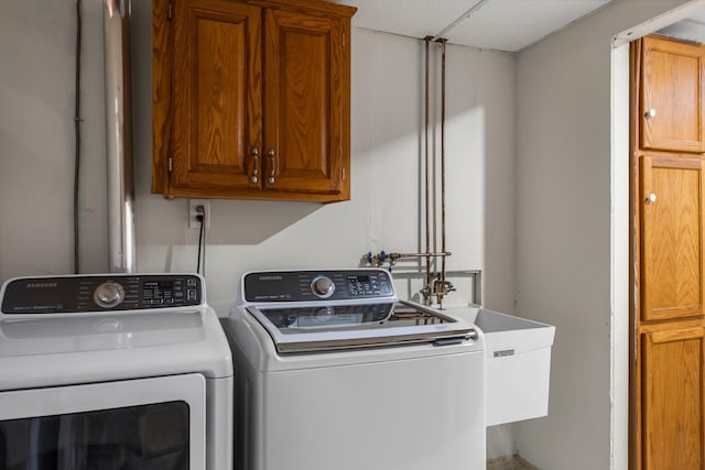 laundry area with cabinet space, a sink, and washer and dryer