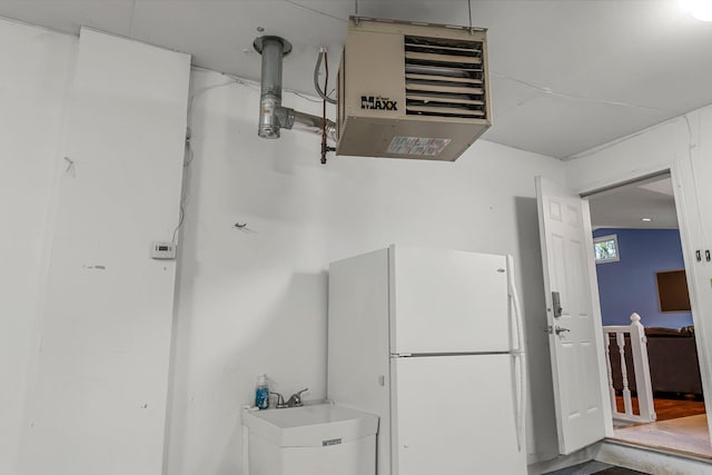 kitchen featuring a sink, freestanding refrigerator, and a heating unit