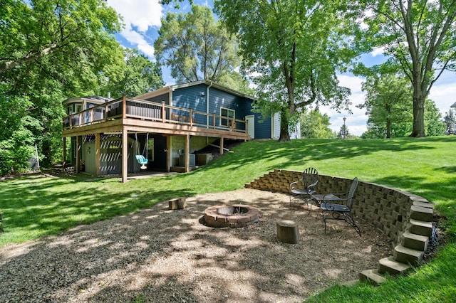 back of house with a yard, a deck, and an outdoor fire pit