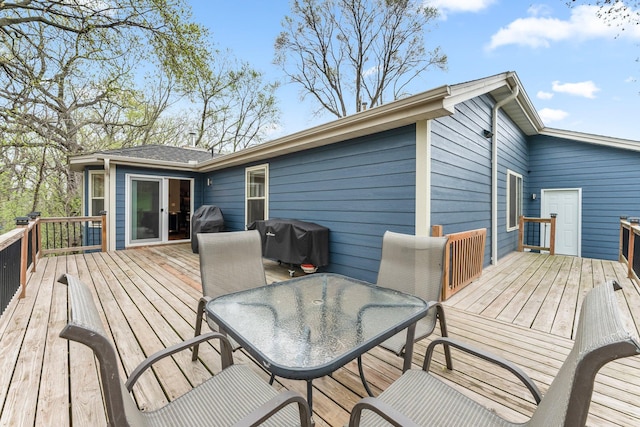 wooden deck with outdoor dining area and area for grilling