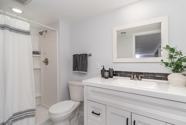 bathroom with toilet, a shower with shower curtain, vanity, and baseboards