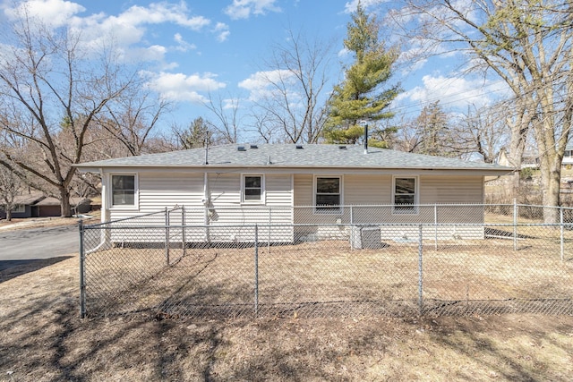 back of house featuring fence, cooling unit, and a shingled roof