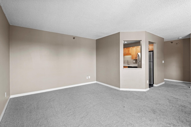 78 10th St E Unit 1410, Saint Paul, MN 55101 - empty room with carpet flooring, baseboards, a sink, and a textured ceiling