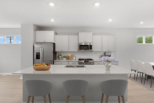 1543 Traverse Ln W, Saint Paul, MN 55118 - kitchen with appliances with stainless steel finishes, a sink, a breakfast bar, a center island with sink, and light countertops