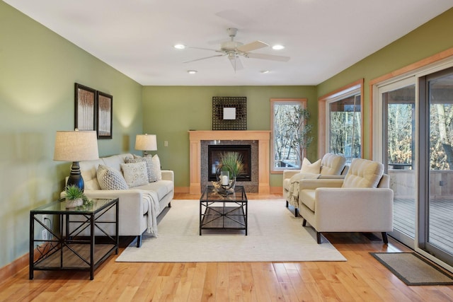 living room with recessed lighting, a high end fireplace, ceiling fan, and wood finished floors