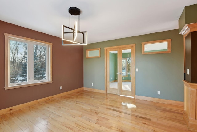unfurnished room with french doors, baseboards, and wood finished floors