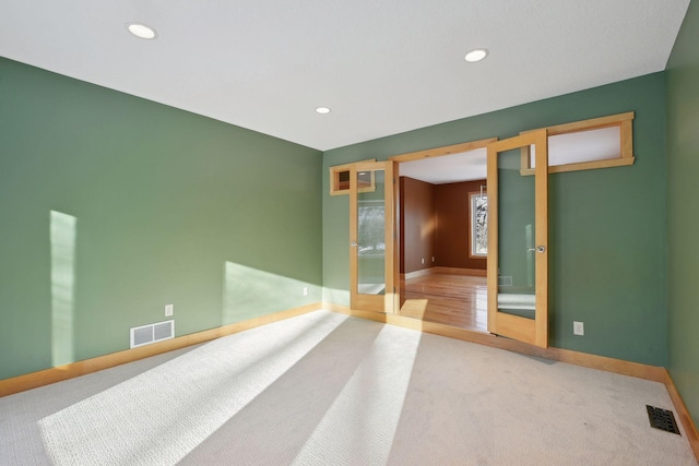 spare room with carpet floors, visible vents, and recessed lighting