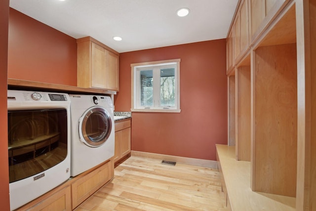 clothes washing area featuring light wood-style floors, separate washer and dryer, visible vents, recessed lighting, and cabinet space