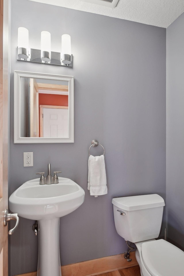 half bath featuring toilet and wood finished floors