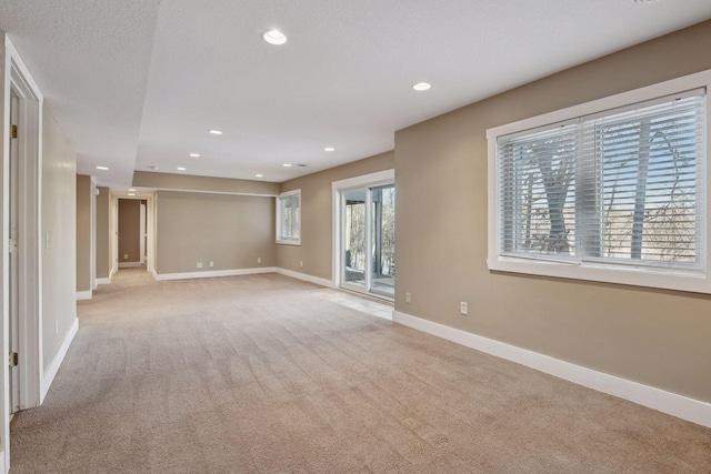unfurnished living room featuring baseboards, recessed lighting, and light carpet