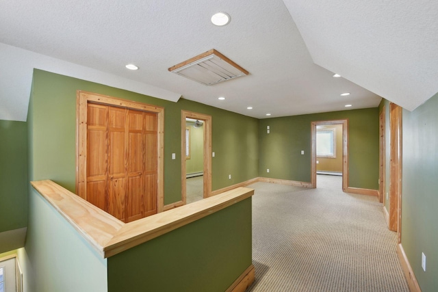 hall with baseboard heating, baseboards, and recessed lighting