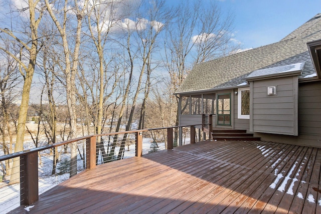 snow covered deck featuring a sunroom