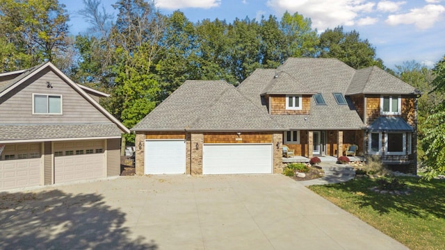 craftsman-style house with concrete driveway, a garage, and a shingled roof