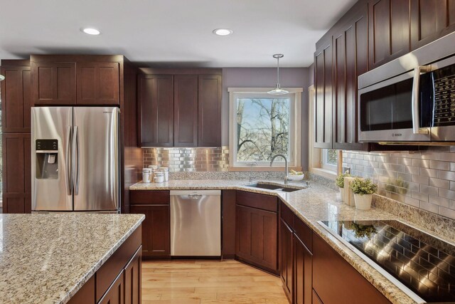 1811 Lake Lucy Ln, Chanhassen, MN 55331 - kitchen featuring stainless steel appliances, a sink, decorative backsplash, light wood-style floors, and recessed lighting