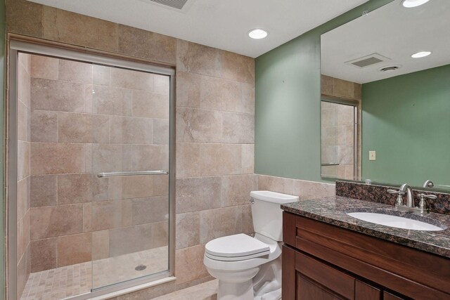1811 Lake Lucy Ln, Chanhassen, MN 55331 - bathroom with tile walls, a tile shower, toilet, vanity, and recessed lighting