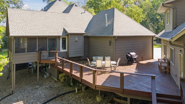 1811 Lake Lucy Ln, Chanhassen, MN 55331 - back of property with a shingled roof, a deck, a sunroom, and outdoor dining area