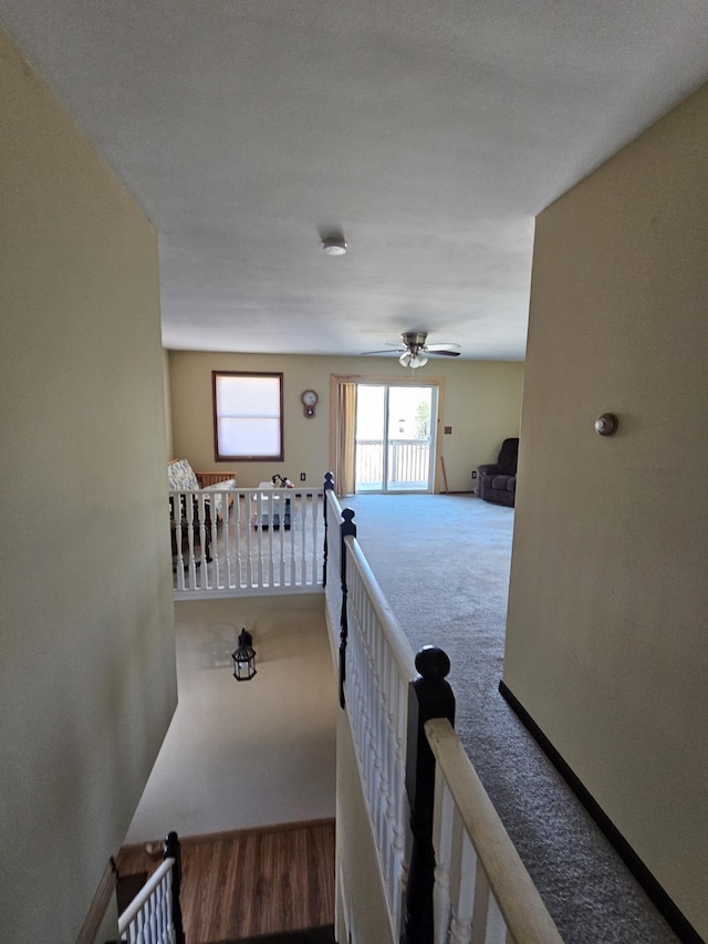 hall with an upstairs landing and carpet