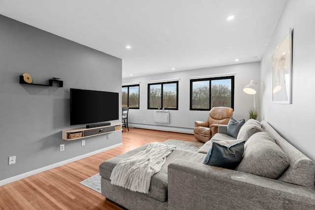 living room featuring a baseboard heating unit, baseboards, wood finished floors, and recessed lighting