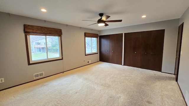 14291 92nd Ave N, Maple Grove, MN 55369 - unfurnished bedroom featuring two closets, visible vents, multiple windows, and light carpet