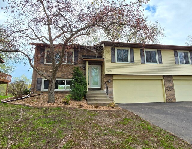 14291 92nd Ave N, Maple Grove, MN 55369 - split foyer home with brick siding, an attached garage, and aphalt driveway
