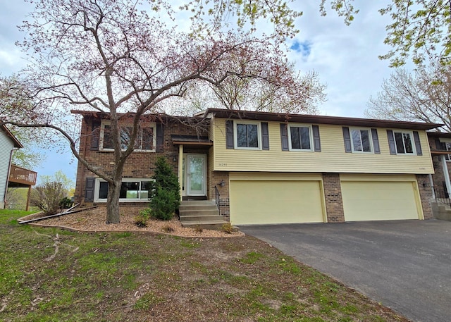 14291 92nd Ave N, Maple Grove, MN 55369 - bi-level home featuring brick siding, a garage, and driveway
