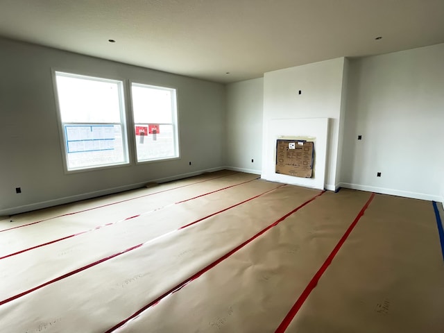 unfurnished living room featuring baseboards