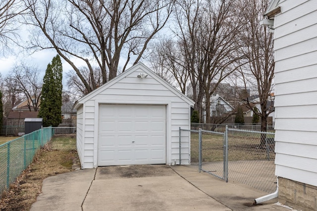 detached garage featuring driveway and fence
