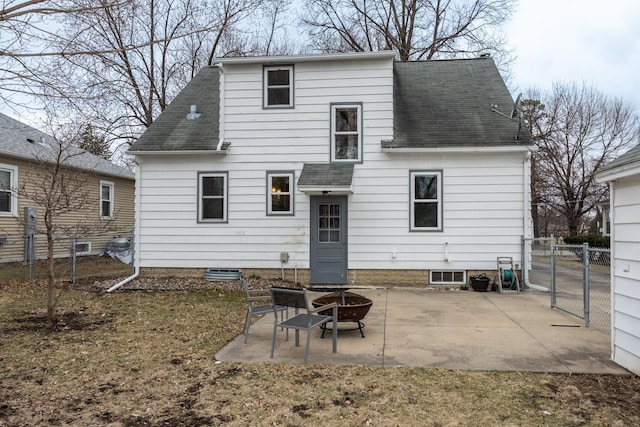 back of property featuring fence, a gate, a fire pit, a shingled roof, and a patio area