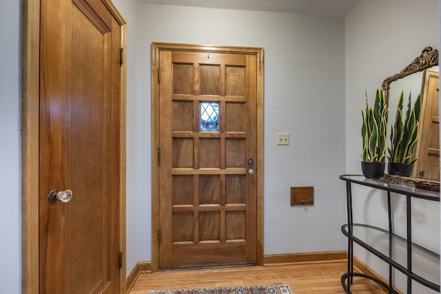 foyer with baseboards and light wood-style flooring