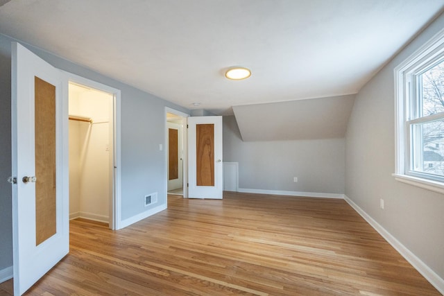 bonus room featuring light wood-type flooring, baseboards, and visible vents