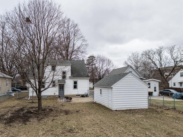 view of side of home with an outdoor structure, a shingled roof, fence, and a storage shed
