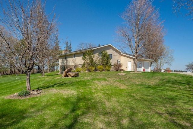 19023 Davis Ave, Faribault, MN 55021 - exterior space featuring a chimney, a front lawn, and an attached garage