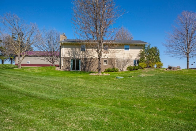 19023 Davis Ave, Faribault, MN 55021 - back of house featuring a chimney and a lawn